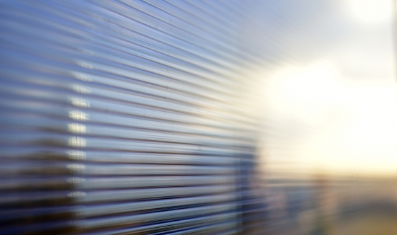 Blue surface of striped polycarbonate with a reflection of the blue distance of the city