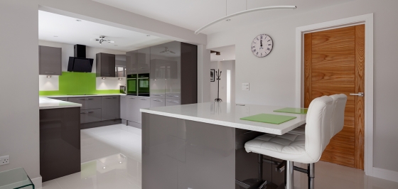 Contemporary fitted kitchen in striking lime green, grey and white colour scheme with built in appliances, white granite counter tops dual ovens island breakfast bar and hob